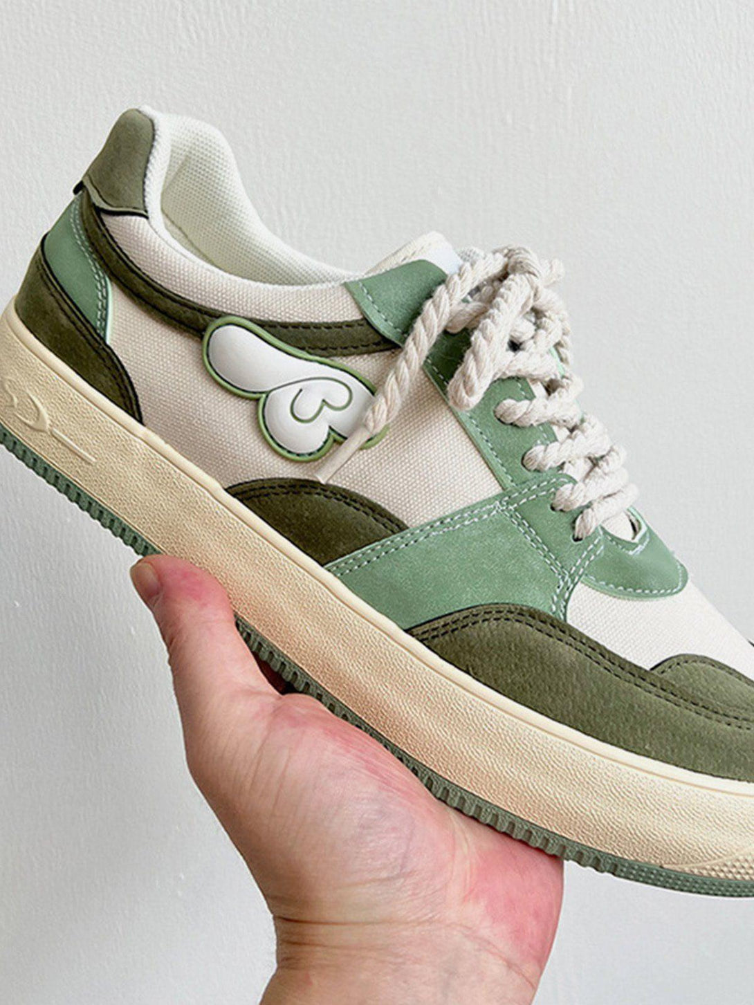 TALISHKO casual shoes with a green colorblock design and wings graphic, shown from the side.