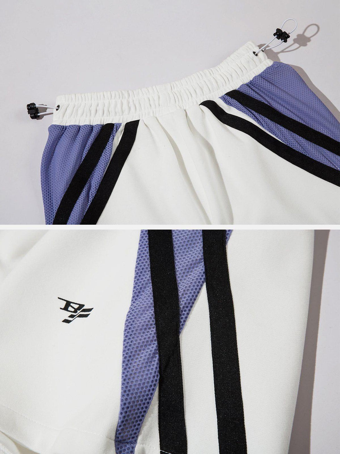 Intricate look at TALISHKO colorblock shorts with purple and black stripes, featuring adjustable waist.