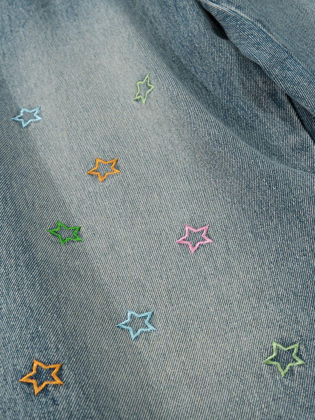 Detailed fabric and star embroidery on loose jeans, showcasing TALISHKO's playful design.