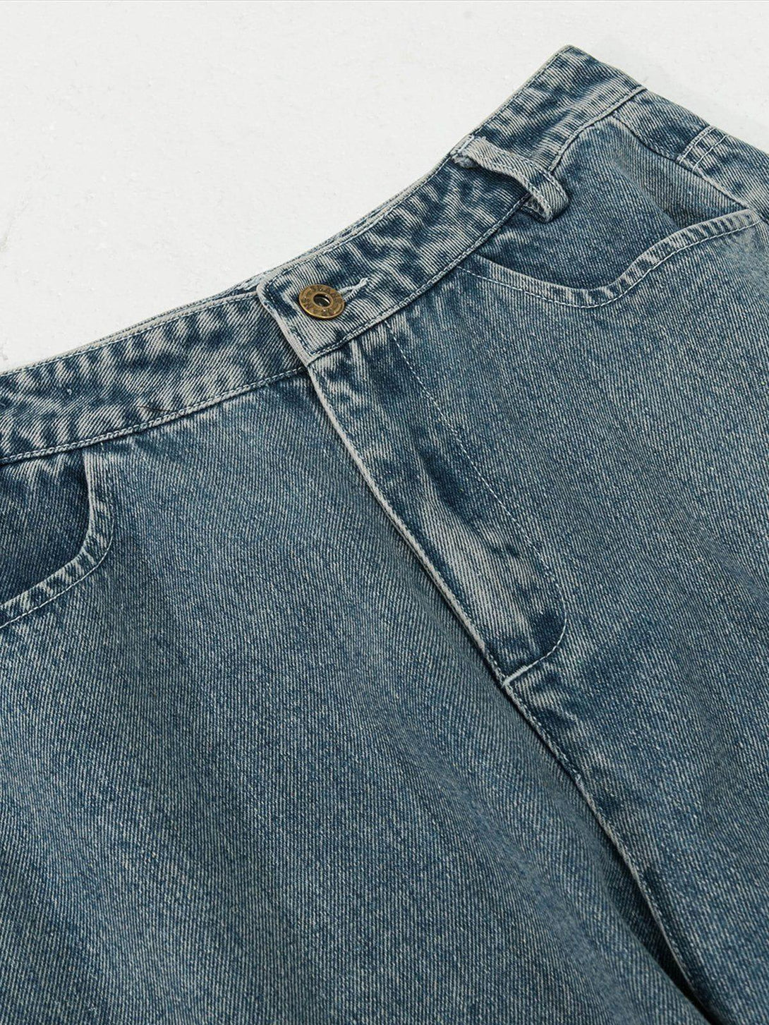A close-up of blue jeans by TALISHKO, highlighting the detailed stitching and button design.