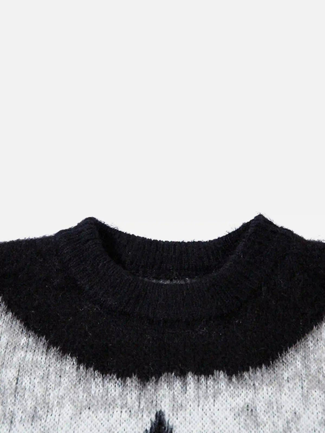A tight crop highlighting the neckline of a TALISHKO sweater with a black and gray pattern.