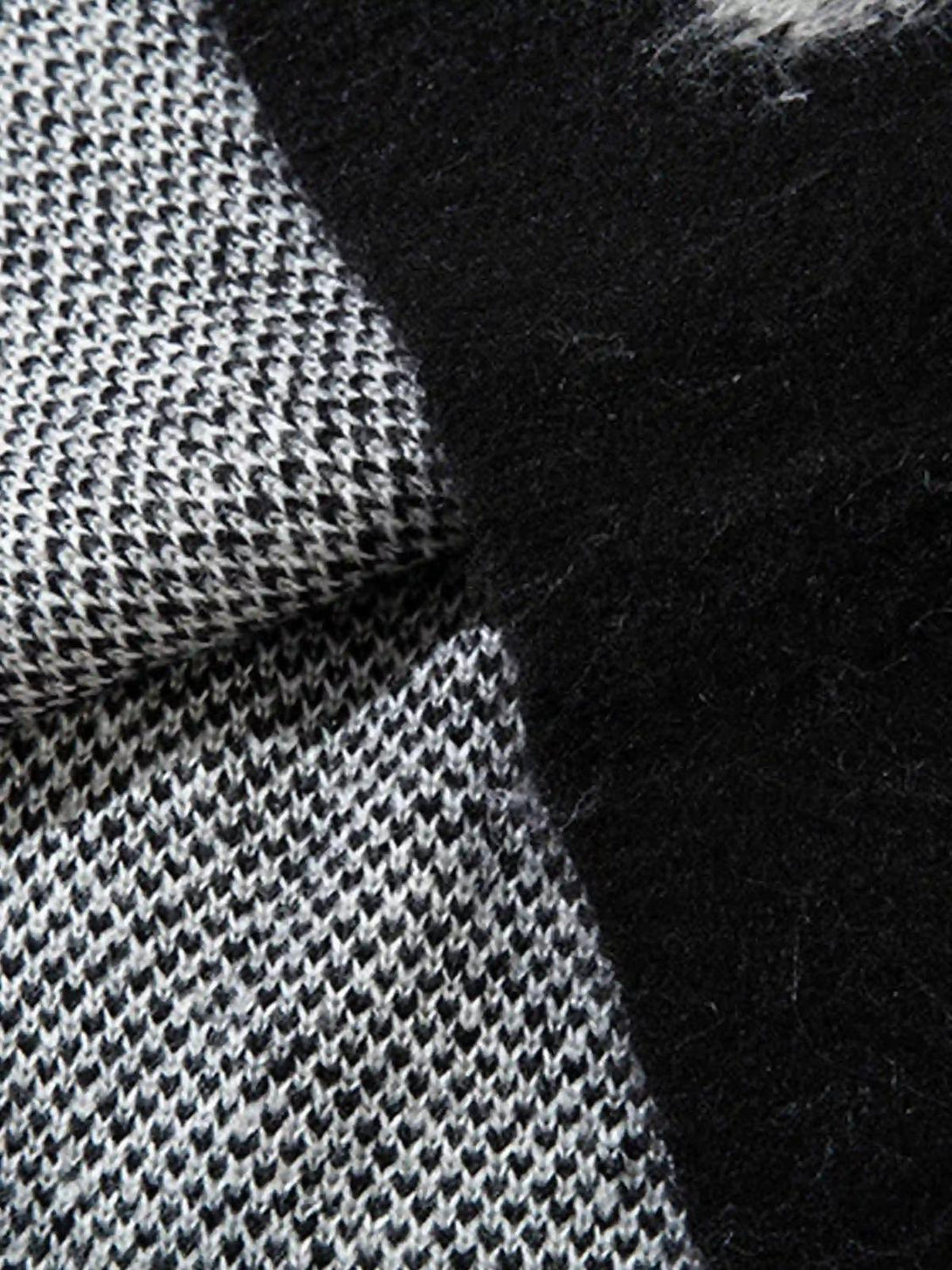 Texture and pattern showcased in a TALISHKO sweater with contrasting black and gray design.