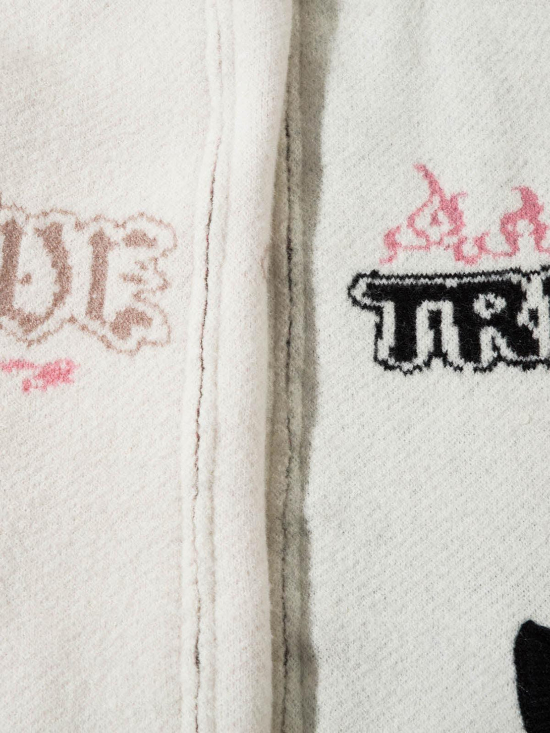 Intricate look at TALISHKO sweater's jacquard design with bold pink and black graphics.
