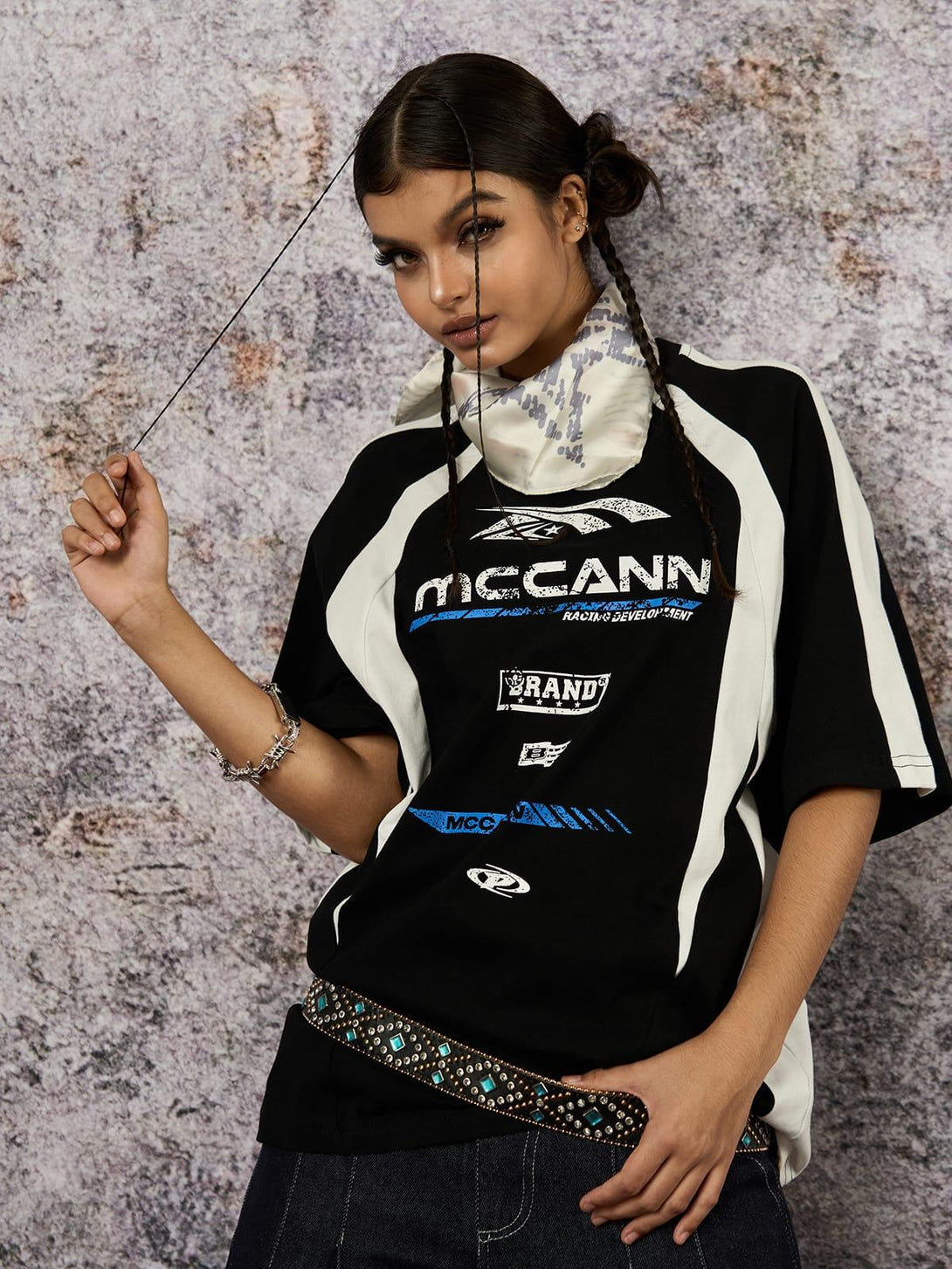 Model wearing a TALISHKO contrast color motorcycle print T-shirt, styled with braided hair.