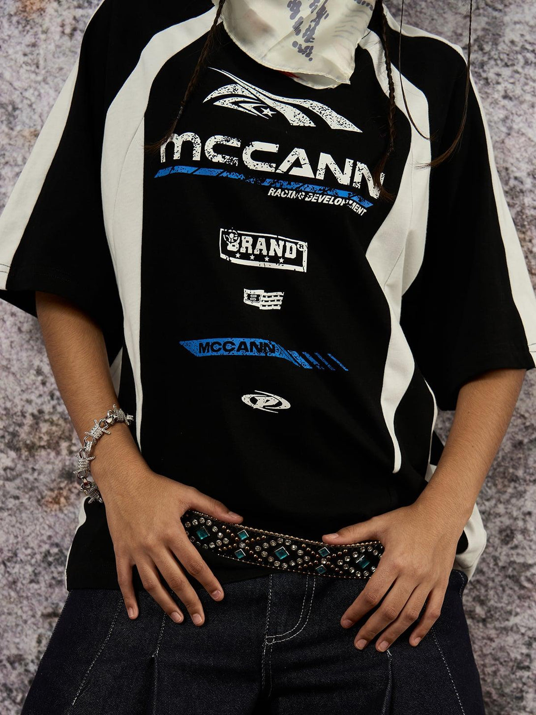 Model showcasing a TALISHKO motorcycle print T-shirt paired with a patterned belt and jeans.