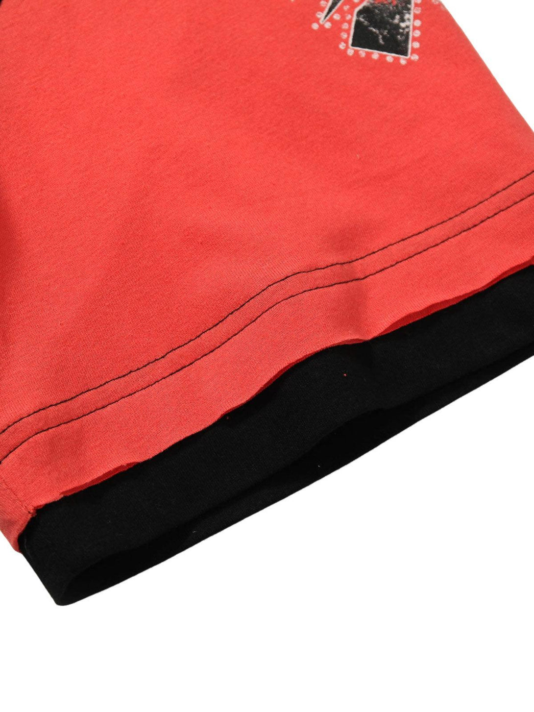 Detailed fabric and stitching of a TALISHKO patchwork print T-shirt with contrasting hem.