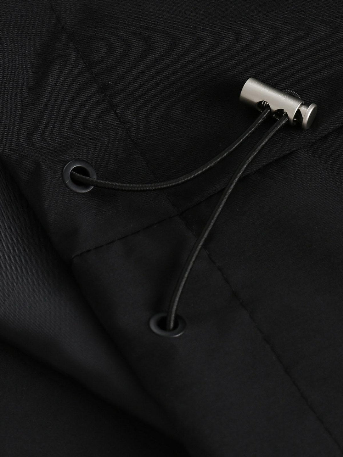 Focusing on the drawstring detail of the black track jacket by TALISHKO.