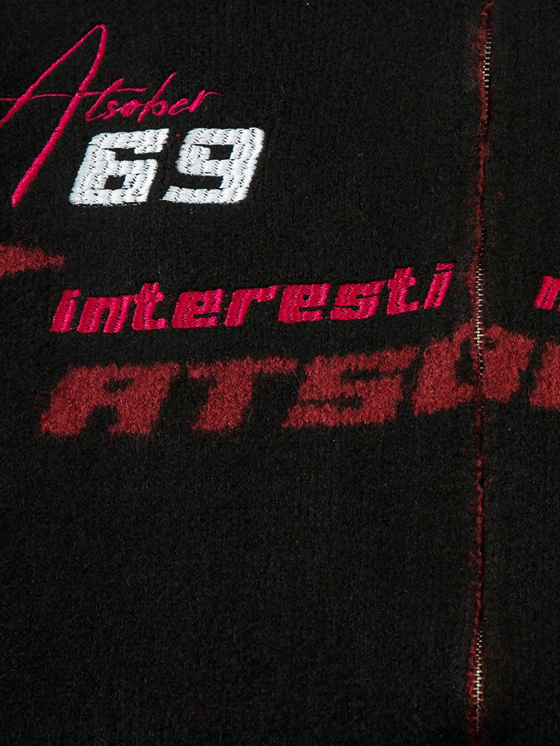 A detailed view of TALISHKO's cardigan, highlighting bold racing graphics and textured fabric.