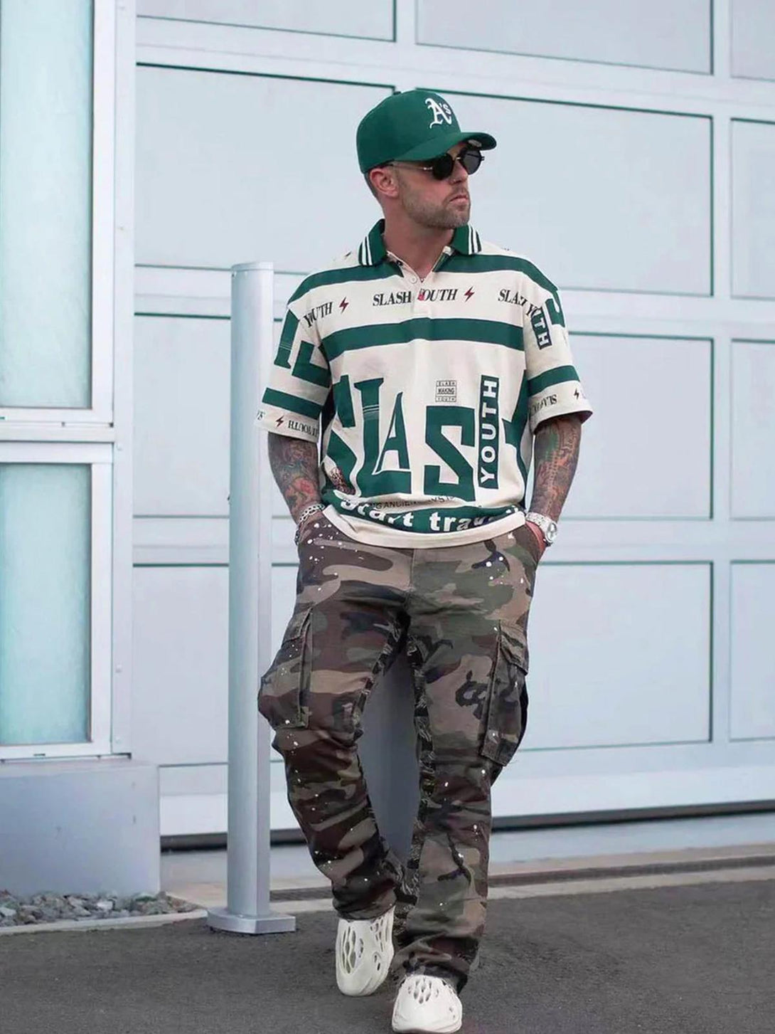 Model styled in TALISHKO's contrast polo shirt with camo pants, capturing urban flair.