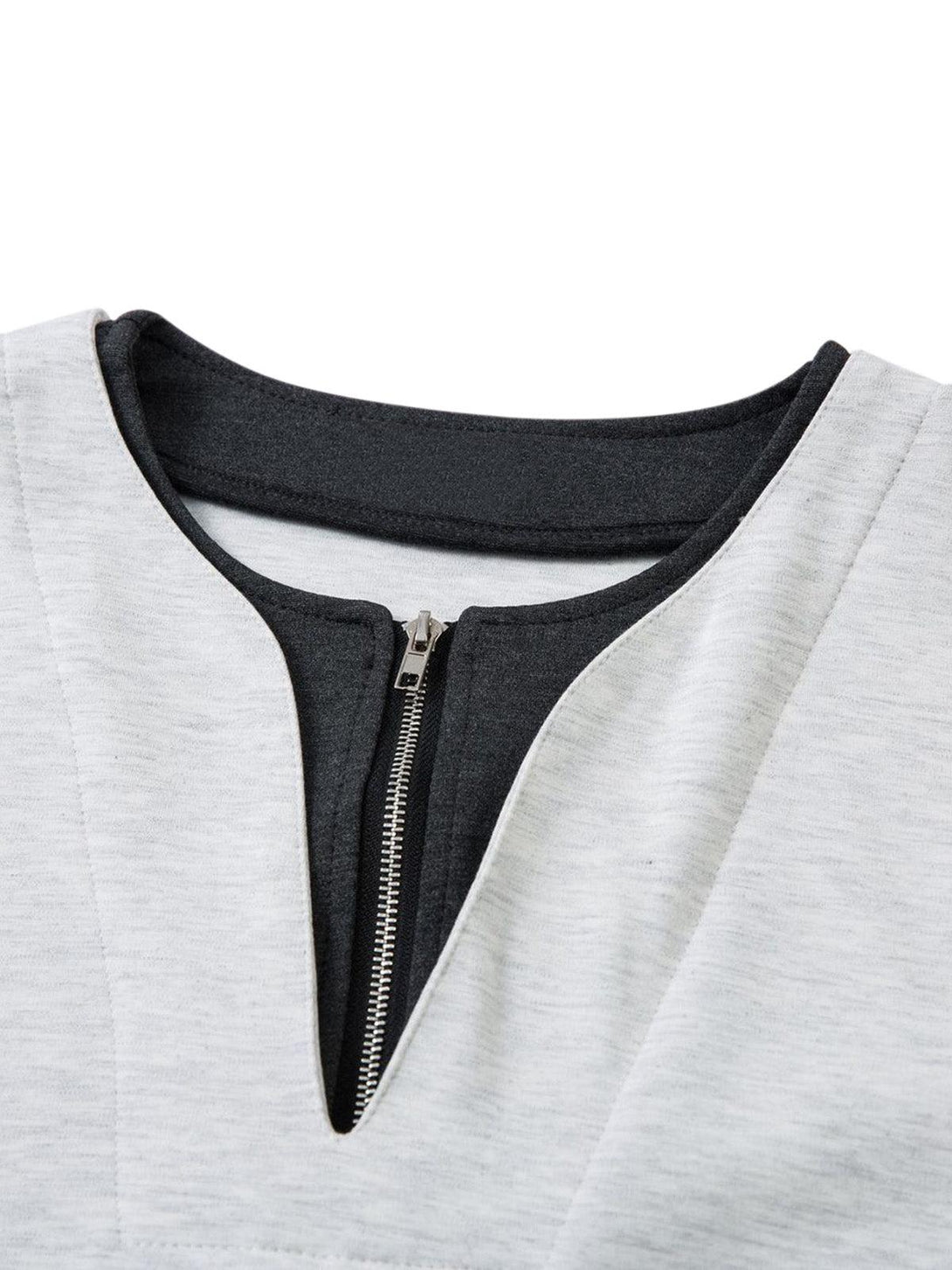 The zipper detail on the faux two-piece T-shirt by TALISHKO showcases contrast stitching.