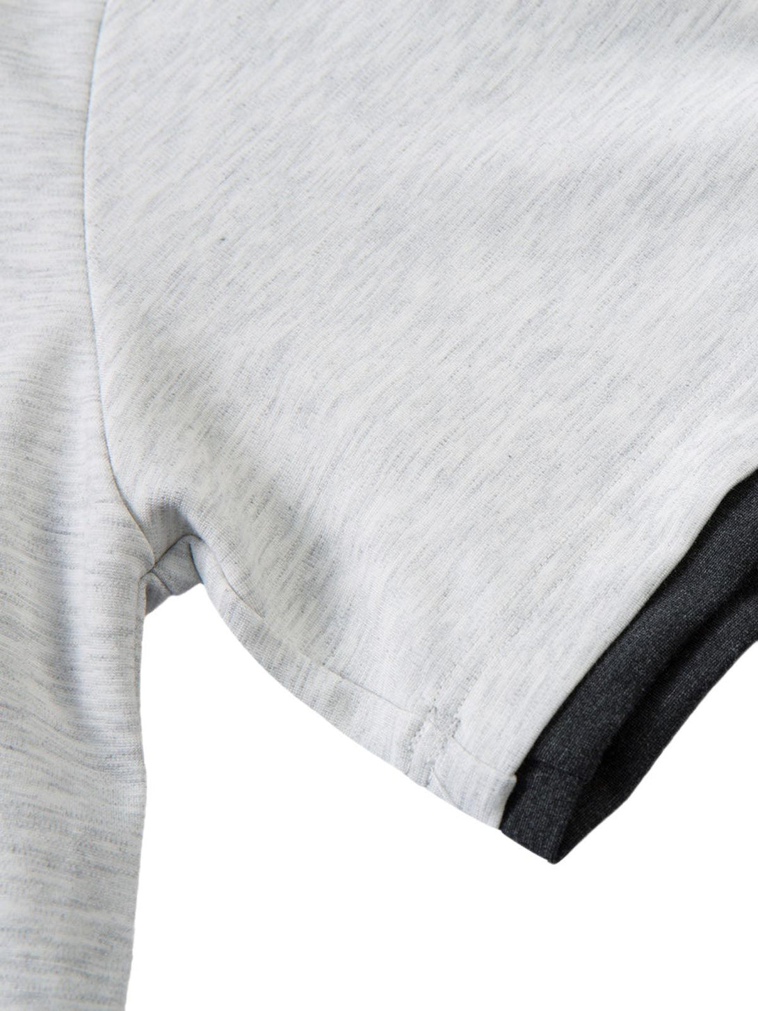 A detailed view of the contrast stitching on a faux two-piece T-shirt by TALISHKO.