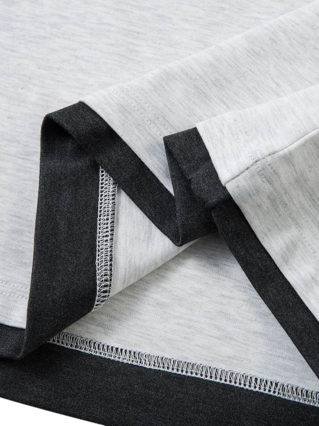 A tight crop highlighting the contrast stitching on a faux two-piece T-shirt by TALISHKO.