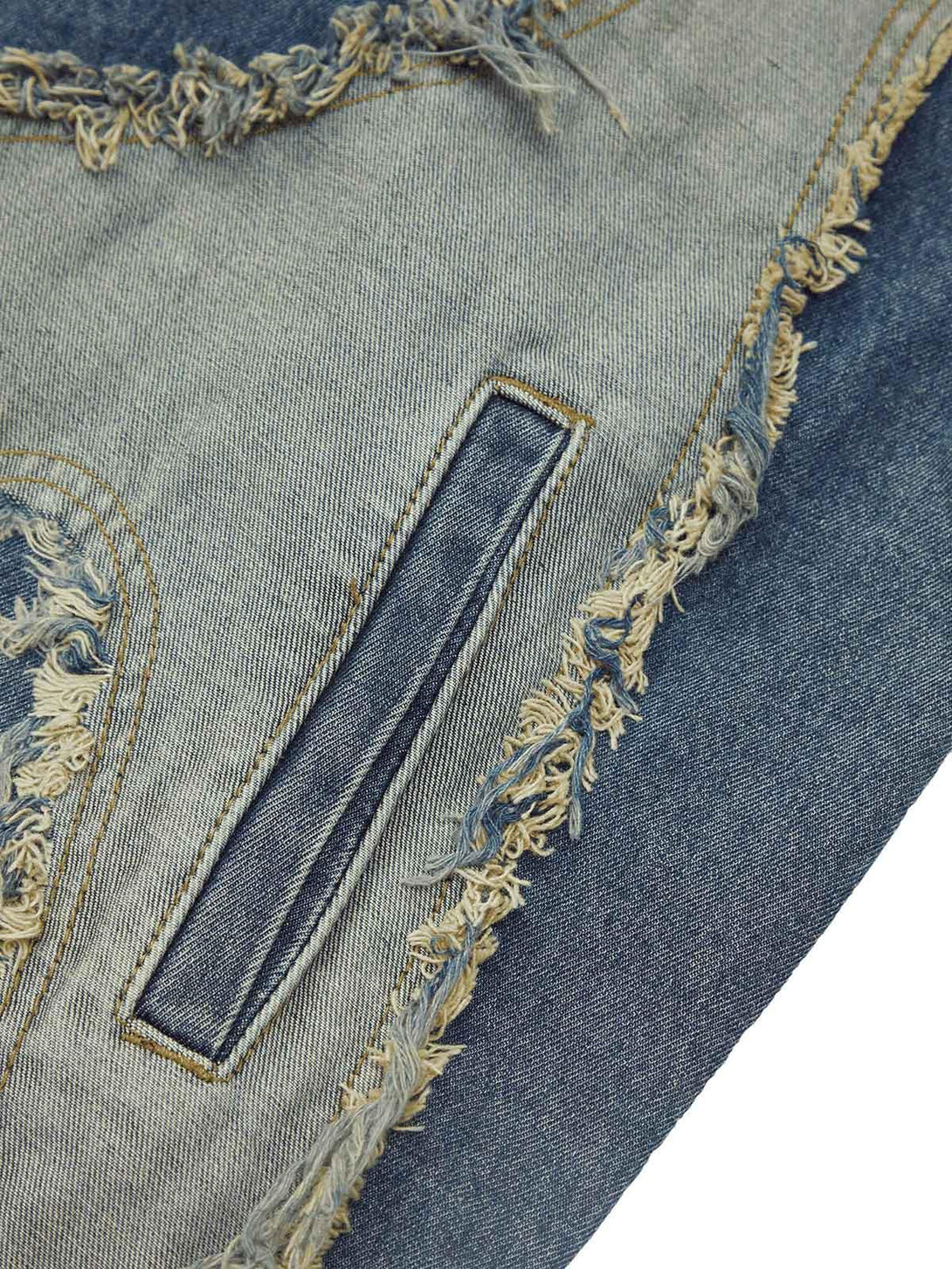 A detailed view of TALISHKO's denim vest with frayed edges and intricate stitching.