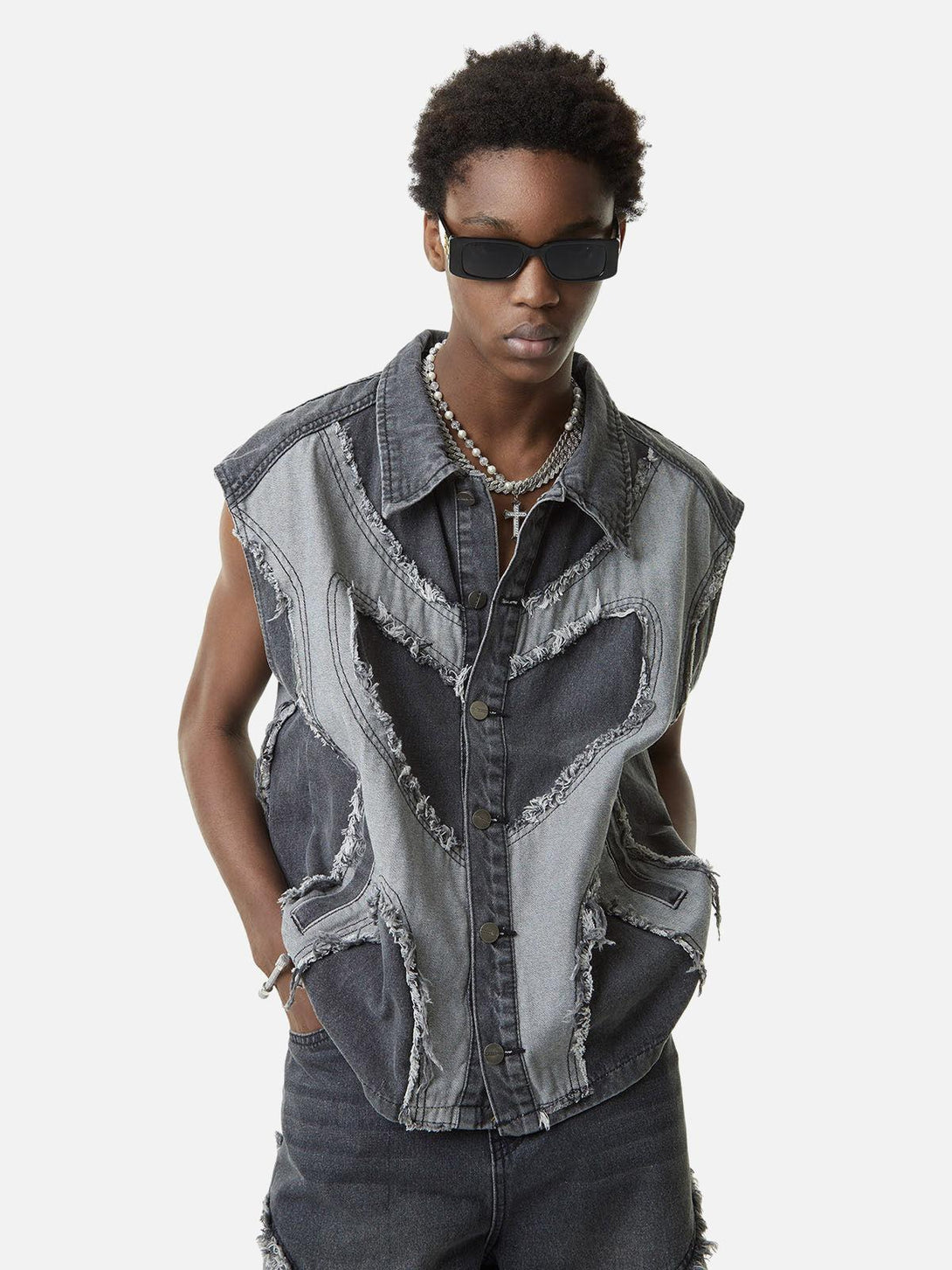 Model in a TALISHKO denim vest with contrast heart stitching and distressed details.