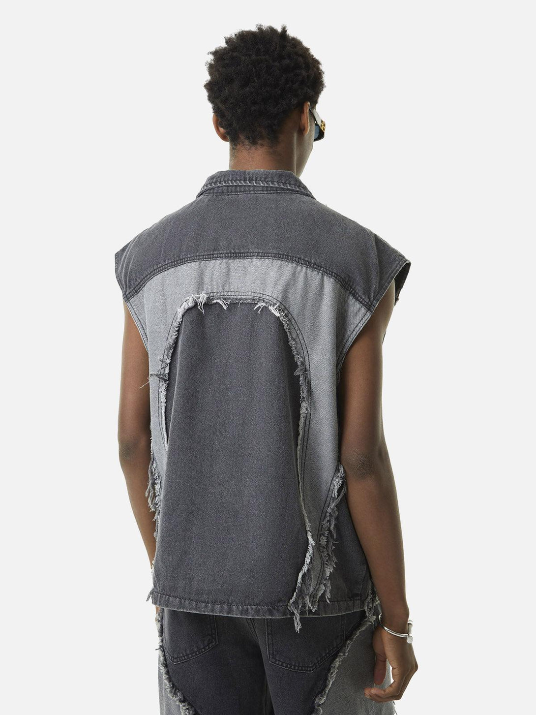 Back view of a TALISHKO denim vest with frayed edges and contrast heart stitching.