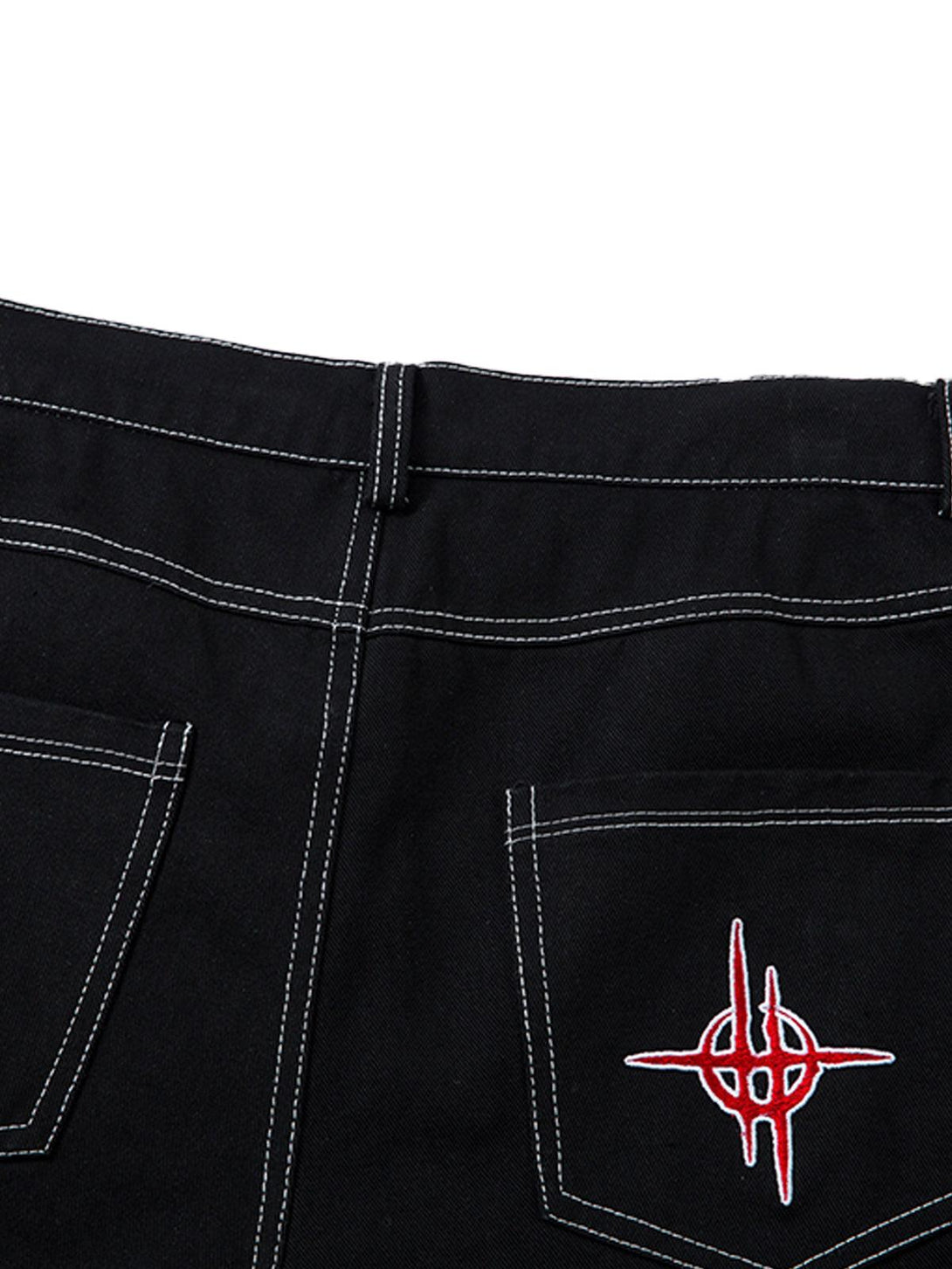 Back pocket detail of TALISHKO's black jeans, highlighting red flame embroidery and contrast stitching.