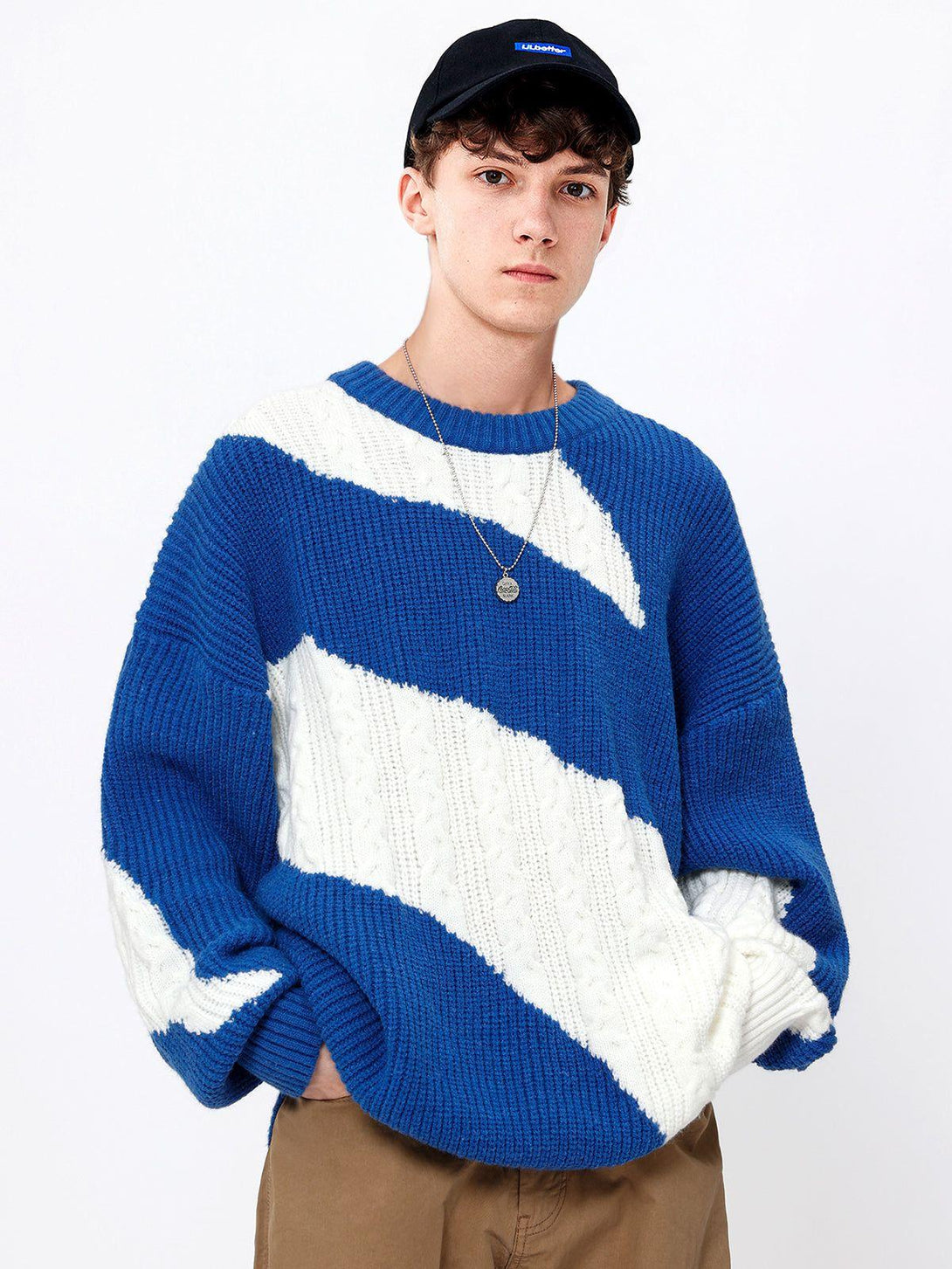 Model wearing a blue and white knit sweater with a unique design by TALISHKO.