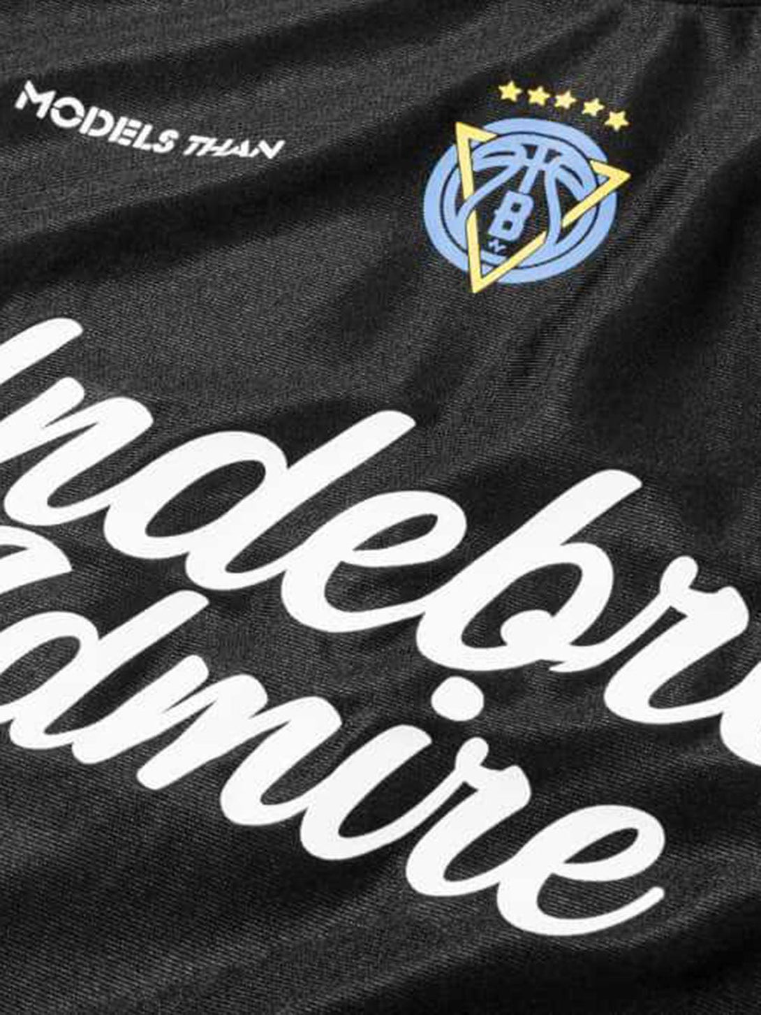 Close-up of a black jersey T-shirt featuring bold lettering and logo accents by TALISHKO.