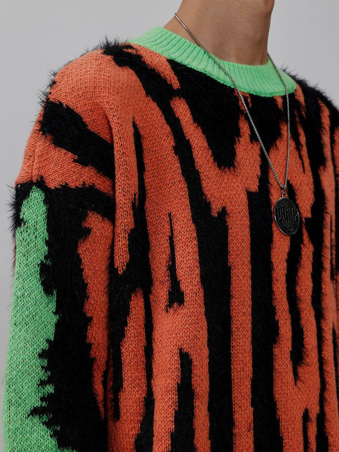 Zoomed-in look at the plush zebra print on a vibrant orange and green TALISHKO sweater.
