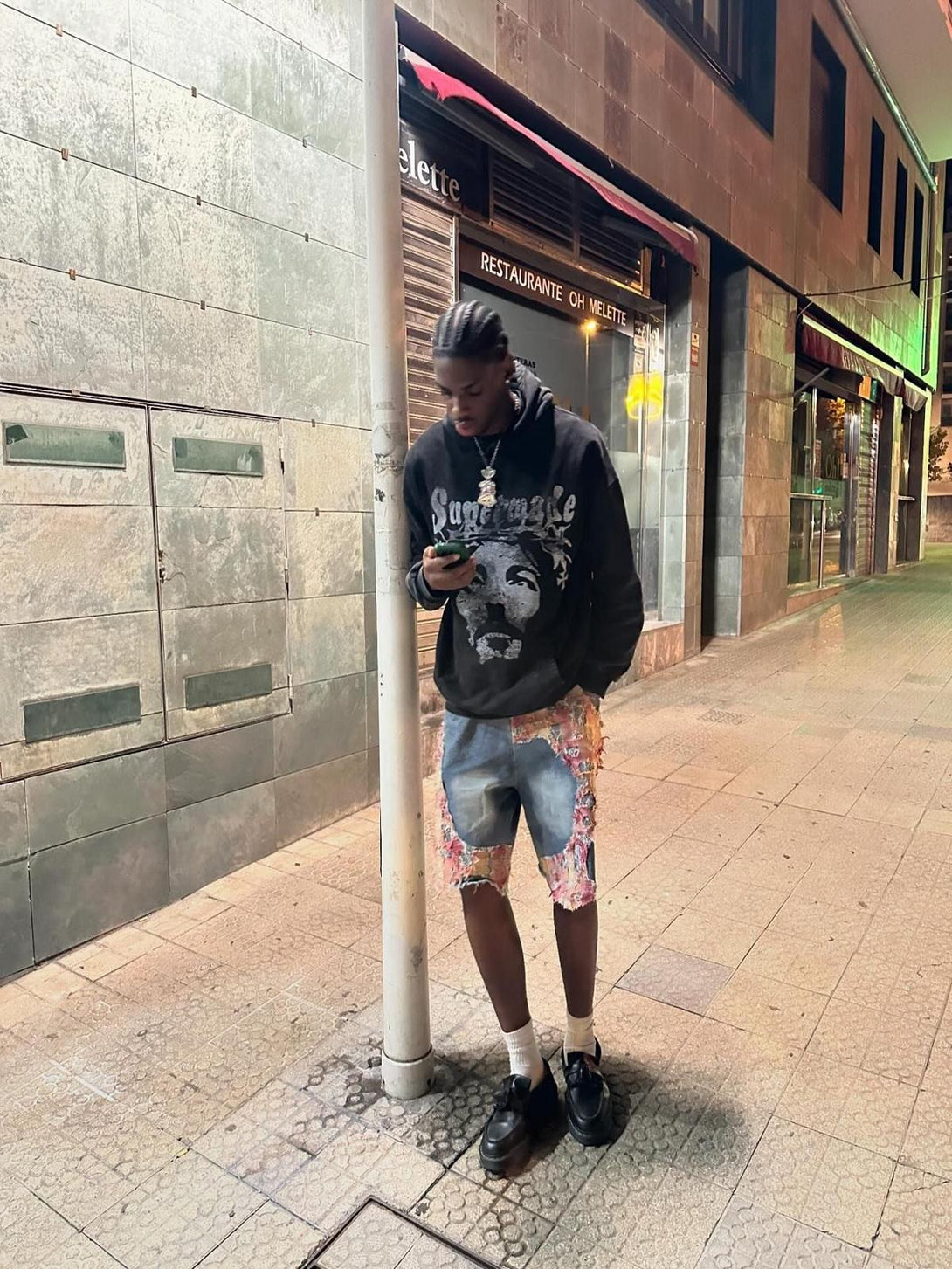 TALISHKO denim shorts with vibrant ripped floral design, worn casually on a city street.