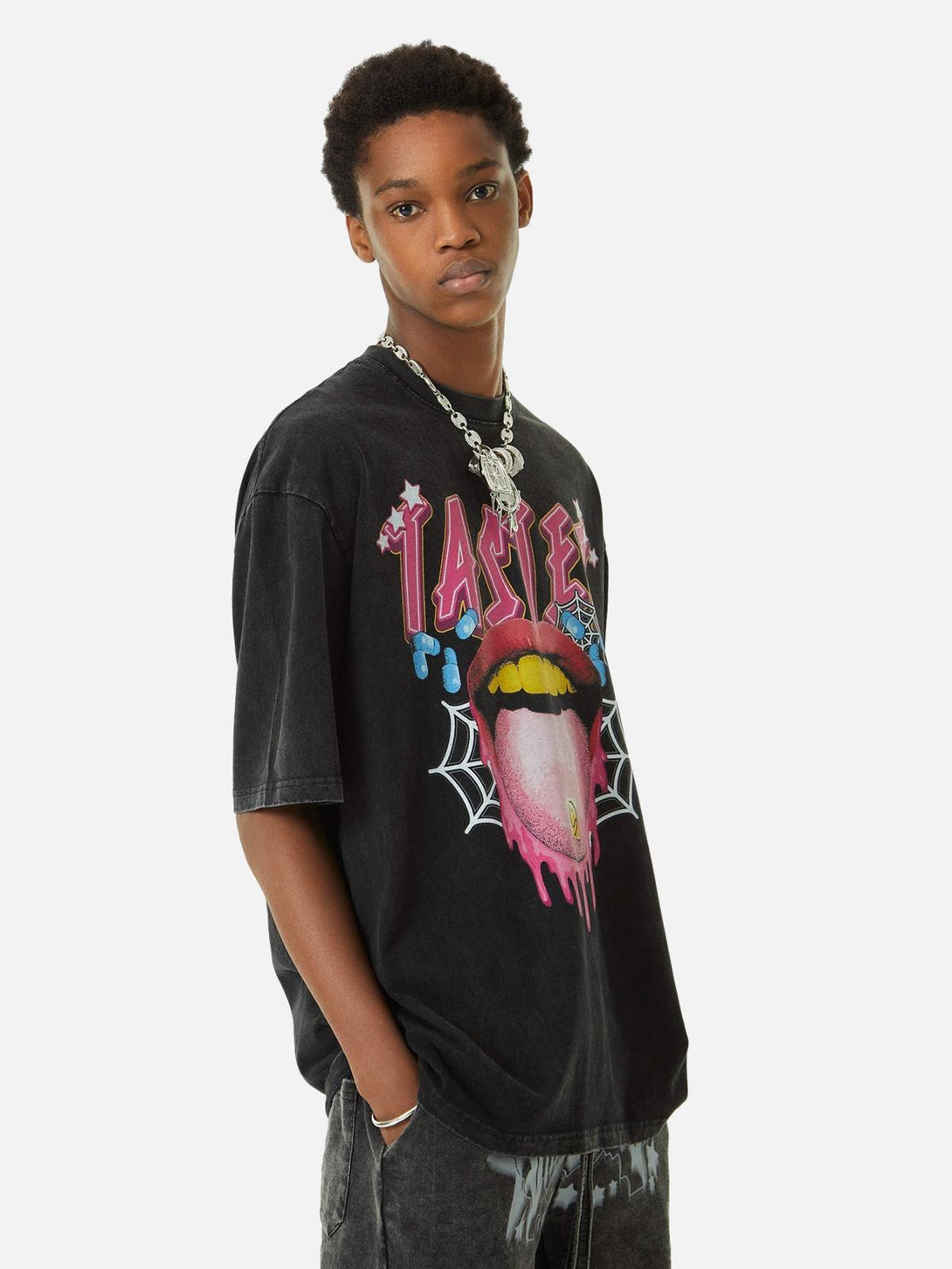 Model in a TALISHKO T-shirt featuring a bold tongue graphic, styled with a chunky necklace.