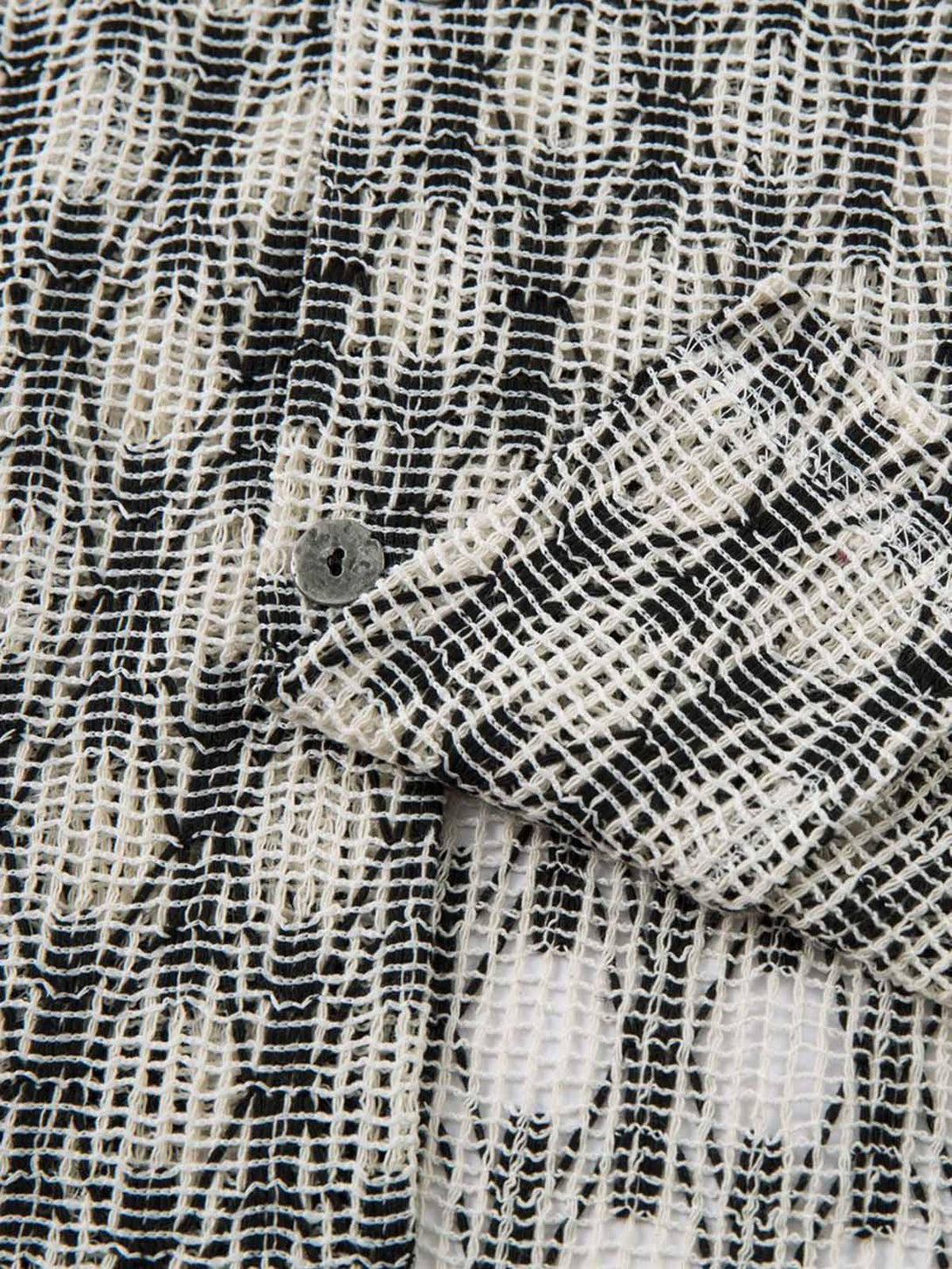 Focusing on the unique weave of the TALISHKO crochet hollow button-up shirt with button detail.