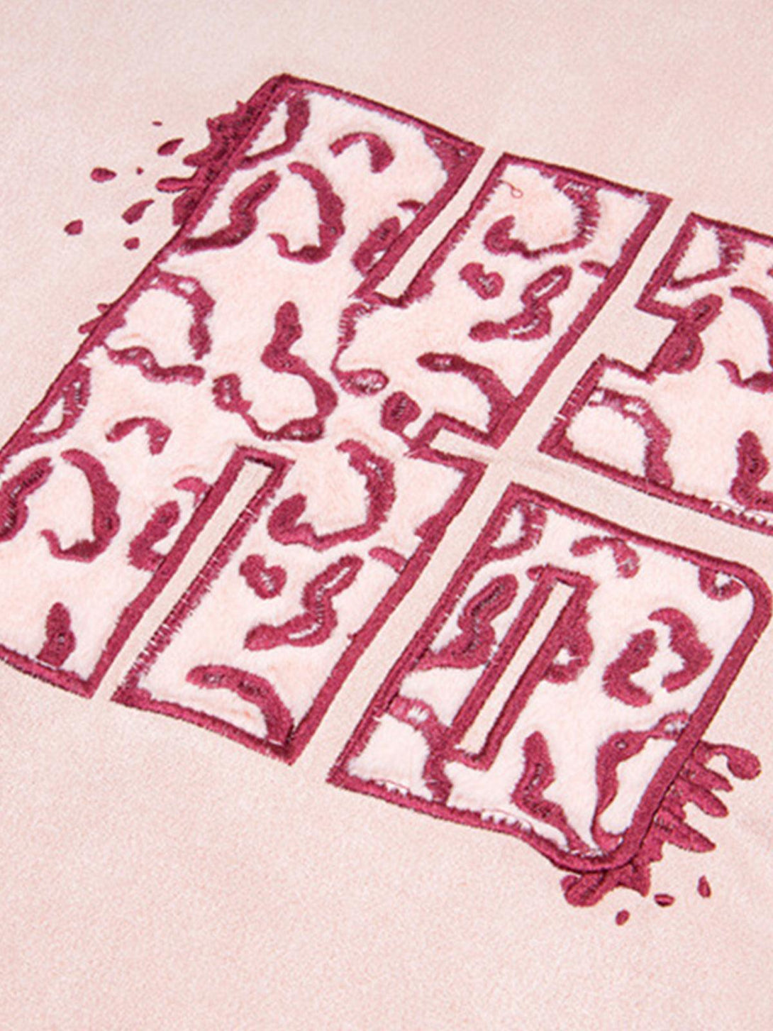 Intricate look at TALISHKO T-shirt's cross pattern with wave details, showcasing its unique texture.