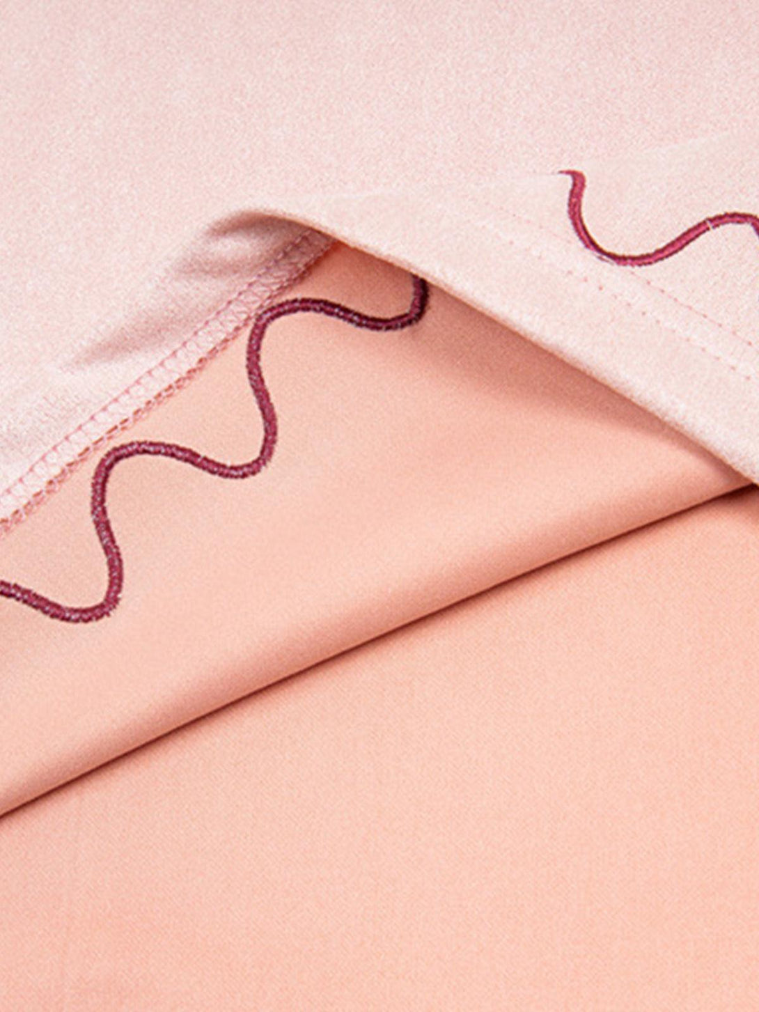 "Detailed fabric and stitching on TALISHKO's T-shirt, showcasing cross and wave design elements."