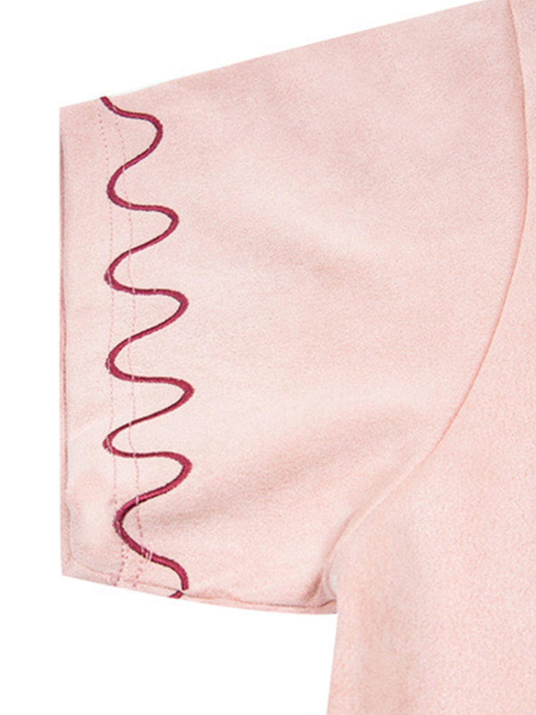 Wavy sleeve stitching detail on TALISHKO's pink T-shirt highlights a playful summer style.