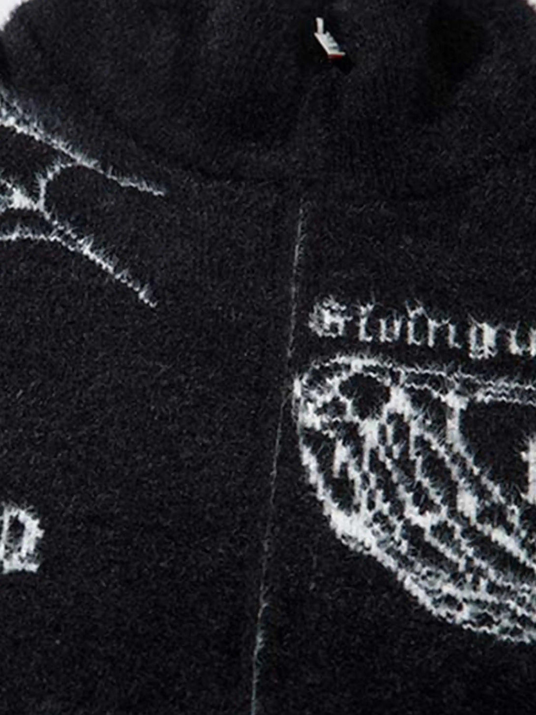 A detailed view of the jacquard texture and gothic motifs on a TALISHKO cardigan.