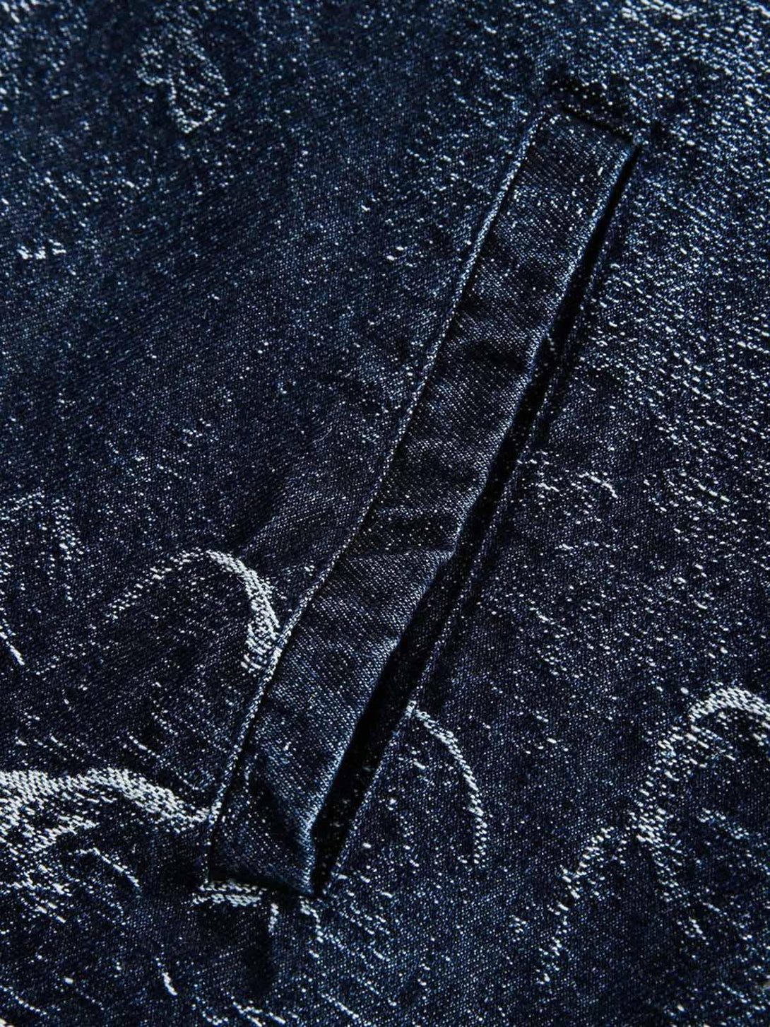 A detailed view of the jacquard texture on a TALISHKO denim jacket, highlighting the pocket design.