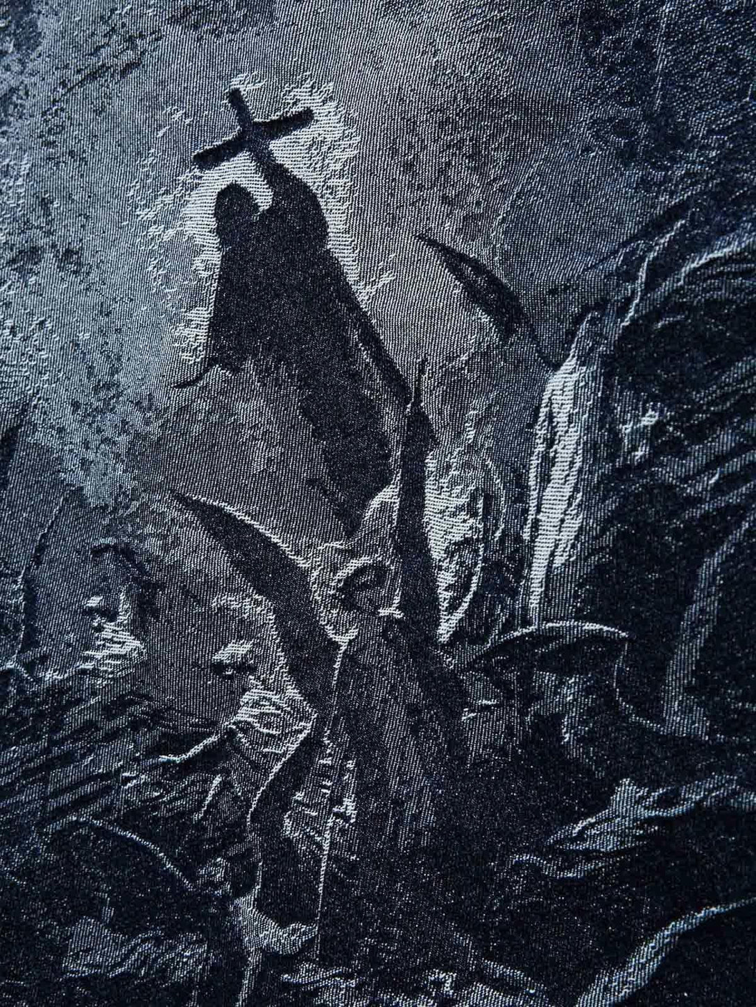 Zoomed-in texture of a TALISHKO jacquard denim jacket showcasing intricate cross design.