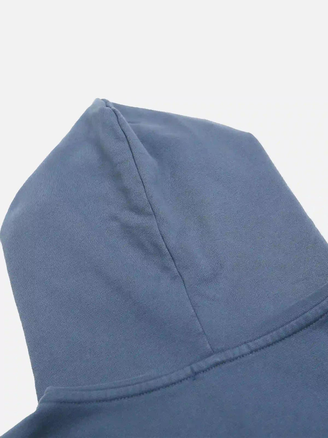 The hood detail of a blue washed hoodie by TALISHKO, highlighting its smooth texture.