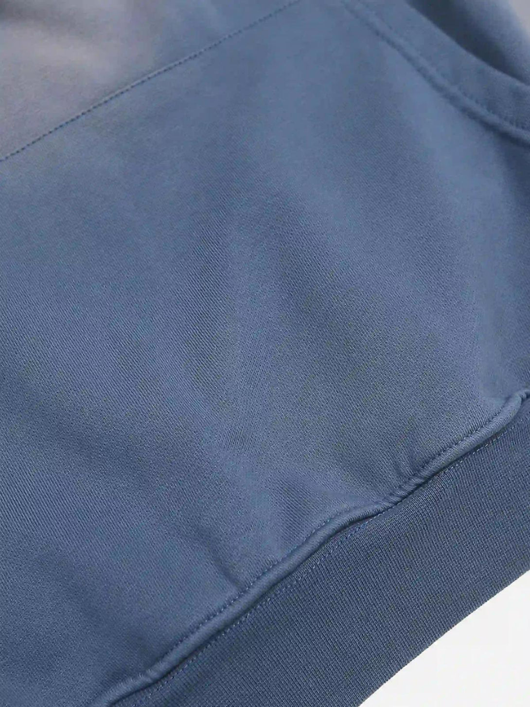 A close-up of a blue washed hoodie fabric by TALISHKO, showcasing its smooth texture.