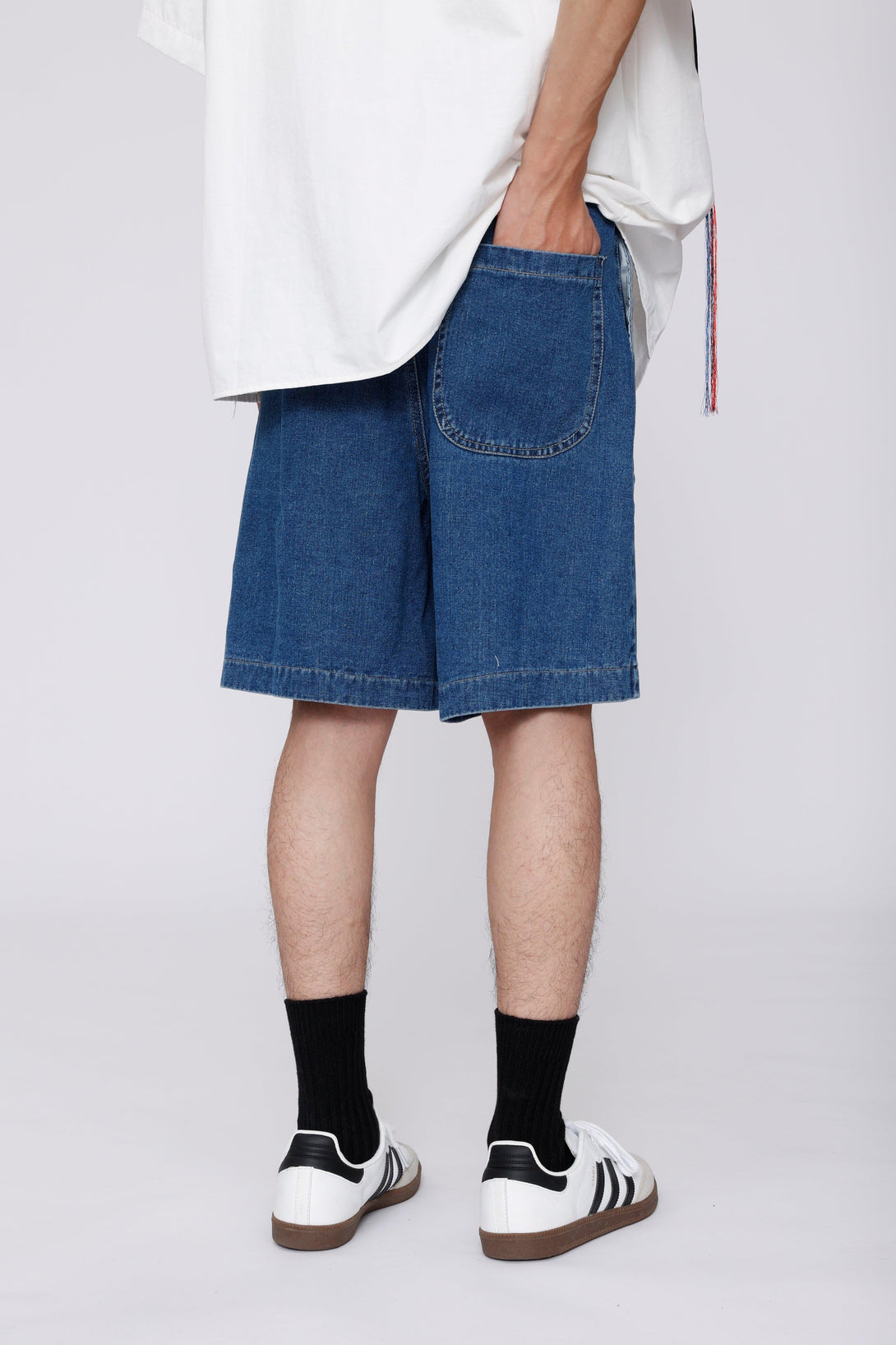 TALISHKO denim jorts with curved pockets, back view paired with sneakers for a relaxed look.