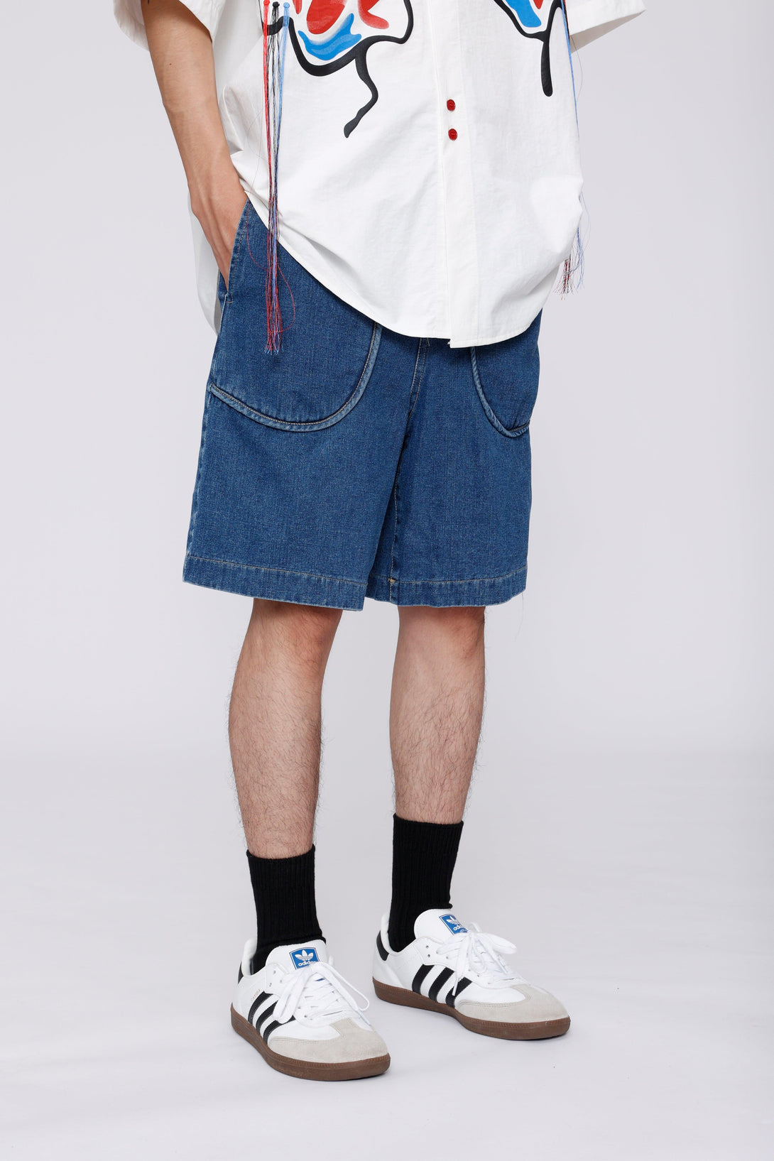 Denim jorts with curved pockets paired with sneakers, featuring TALISHKO's casual style.