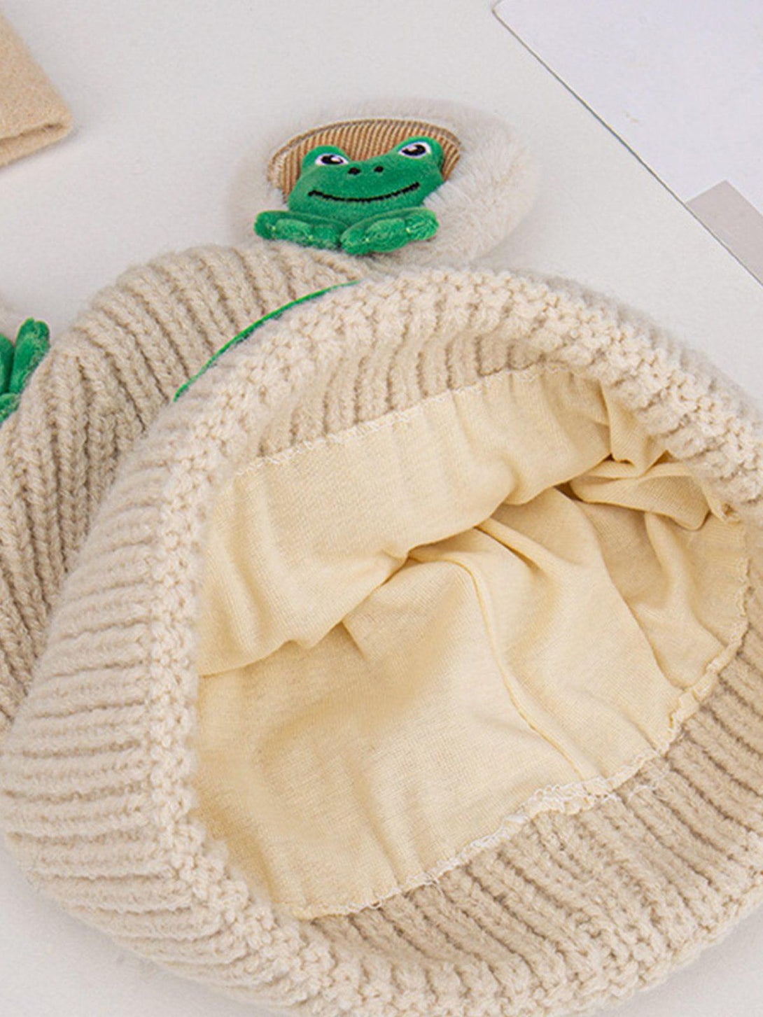 TALISHKO cozy knitted hat featuring a cute 3D frog detail, showcasing soft interior lining.