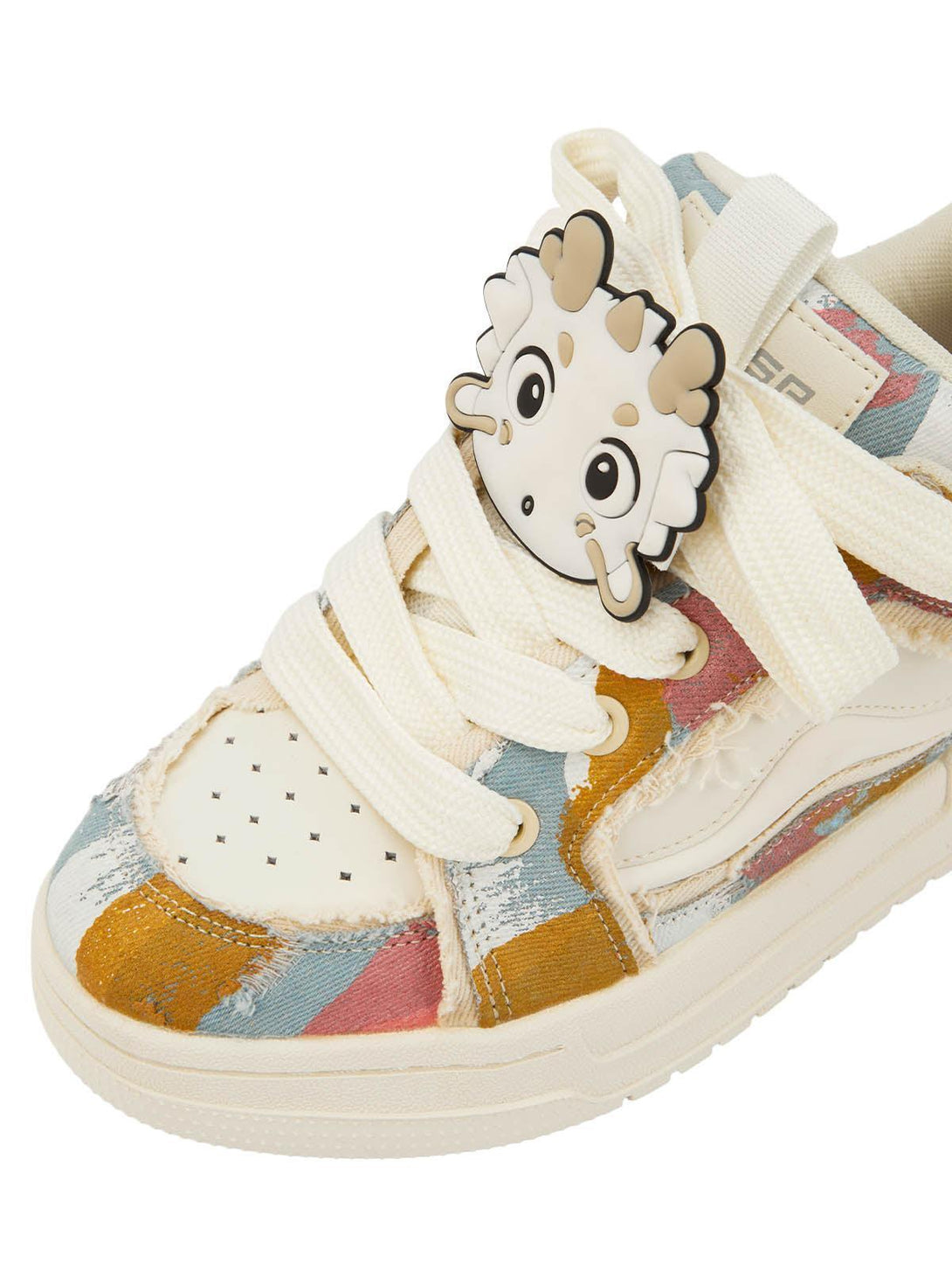Close-up of TALISHKO sneakers with playful dragon charm and colorful abstract pattern.
