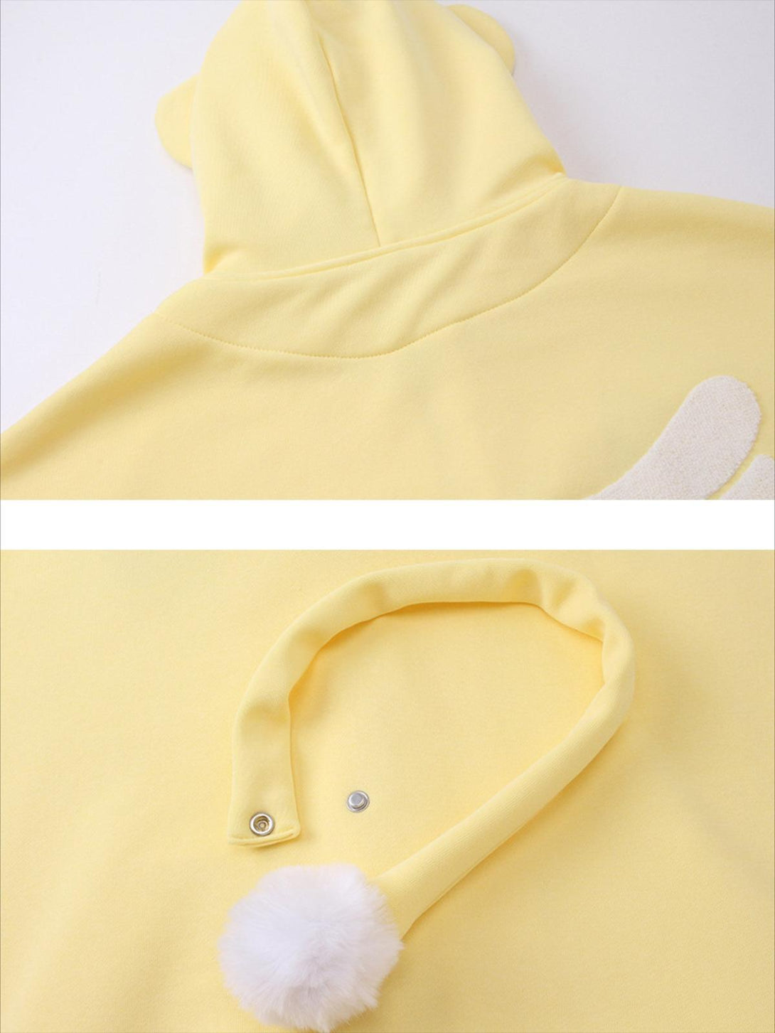 Detailed view of yellow hoodie with detachable tail and fluffy pom-pom by TALISHKO.