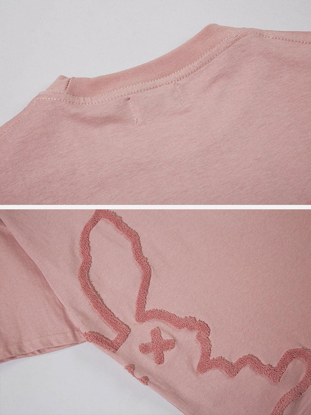 Detailed fabric and design of a pink tee by TALISHKO, showcasing rabbit embroidery.