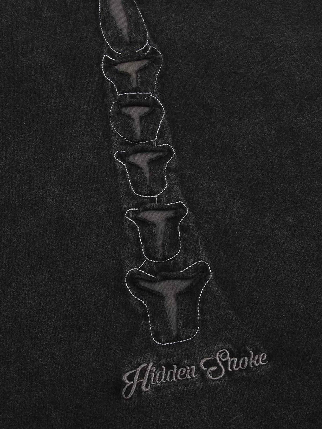 Intricate look at the bone design on TALISHKO's dark washed T-shirt, showcasing unique style.