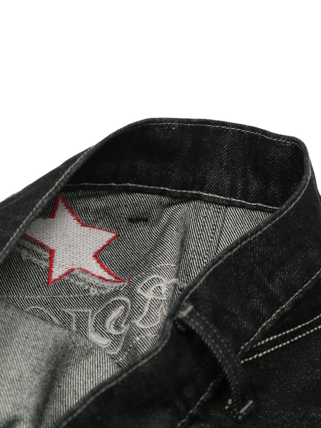 Inside view of TALISHKO's gothic jeans, showcasing red star embroidery and intricate lining design.