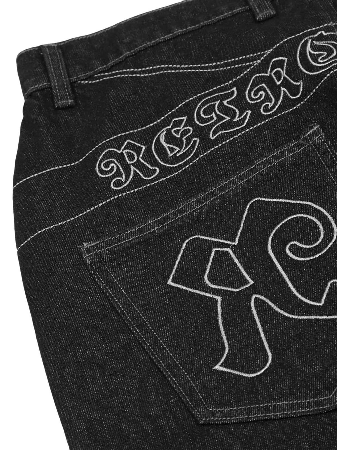 Focusing on TALISHKO's dark gothic jeans, highlighting white embroidery and unique back pocket design.