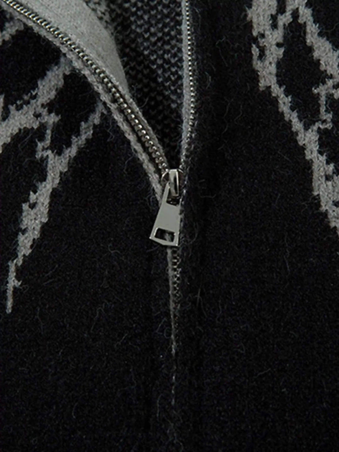 "Detailed view of the zipper and spider web pattern on a dark cardigan by TALISHKO."