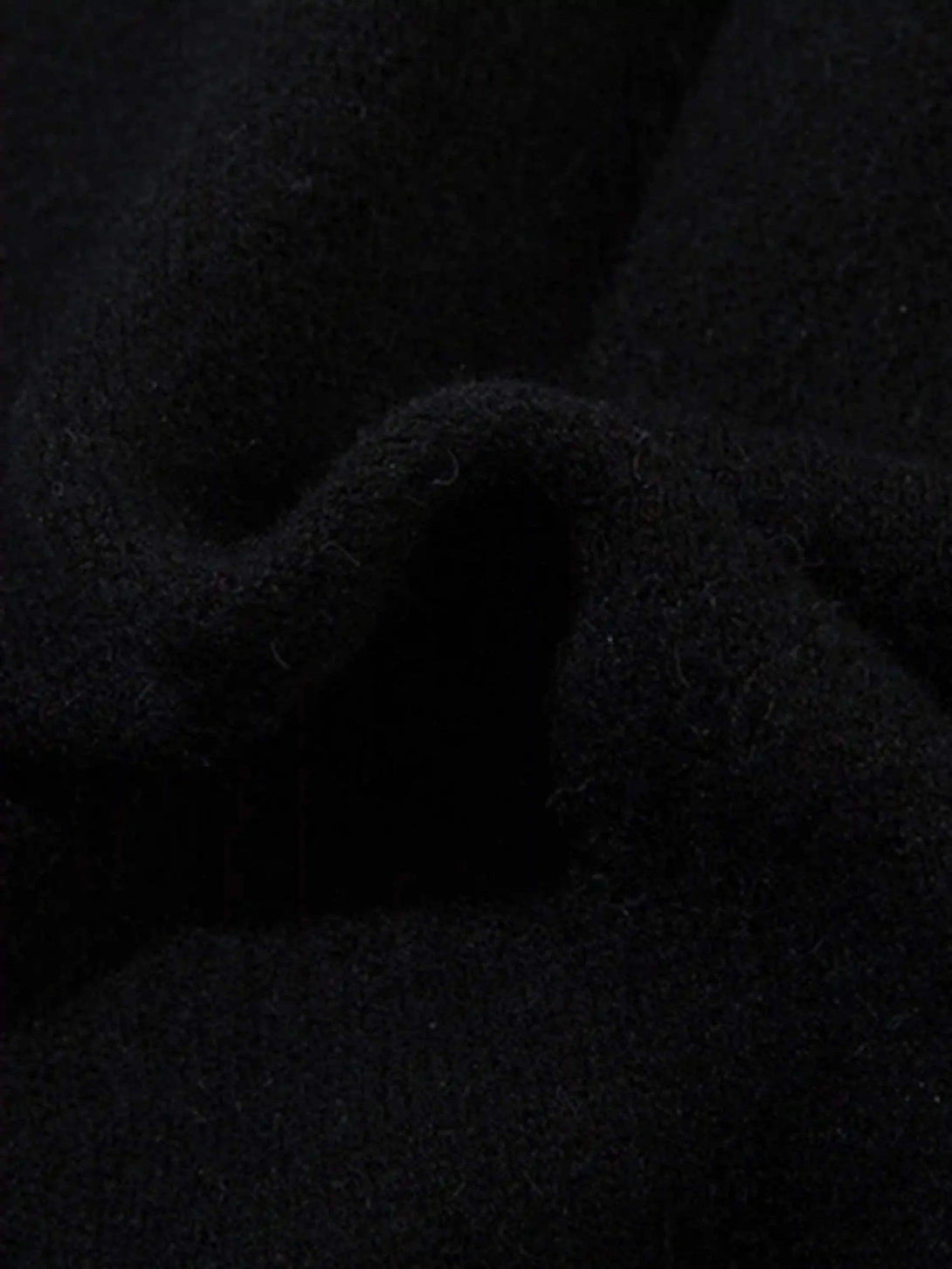 "Zoomed-in texture of the dark cardigan fabric, showcasing intricate details by TALISHKO."