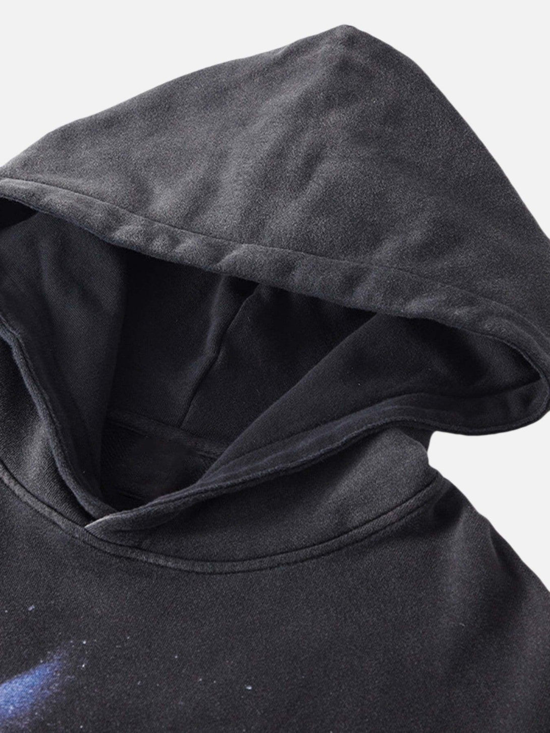 A detailed look at the hood of TALISHKO's dark loose sweatshirt, emphasizing its soft fabric.