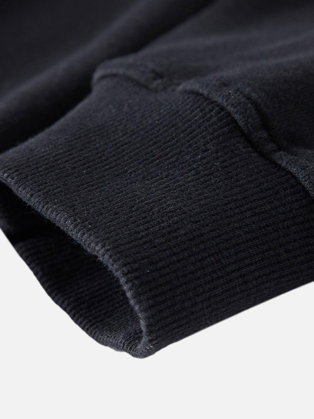 Focusing on the cuff detail of TALISHKO's dark hooded sweatshirt, showcasing the ribbed texture.