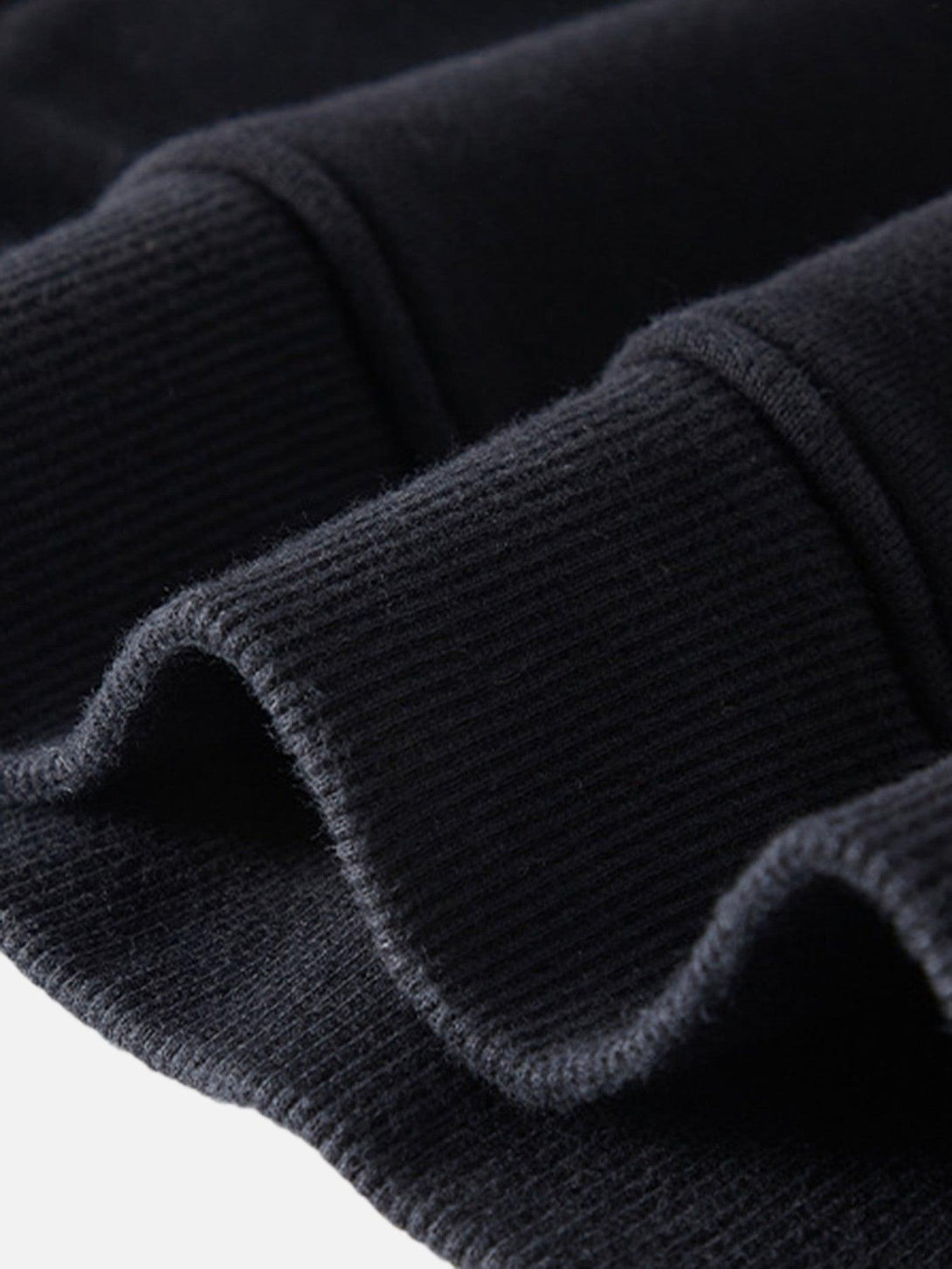 Detailed fabric and stitching of a dark hooded sweatshirt by TALISHKO, showcasing texture.