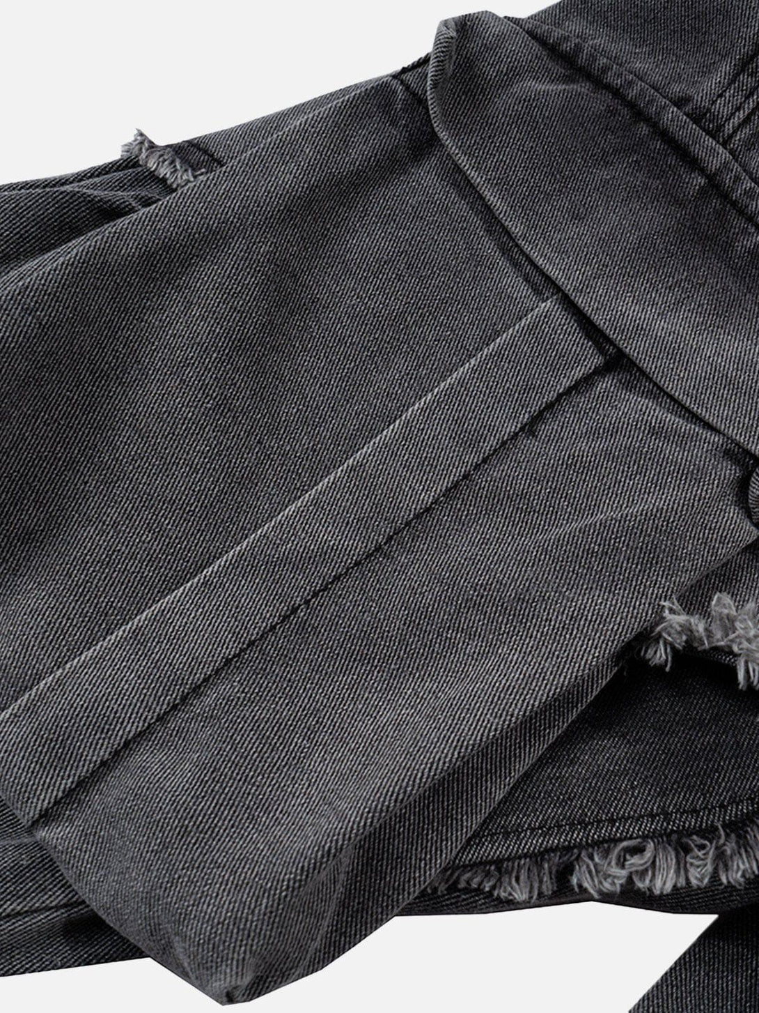 Zoomed-in texture of TALISHKO's deconstructed jeans, highlighting fringe details and large pockets.