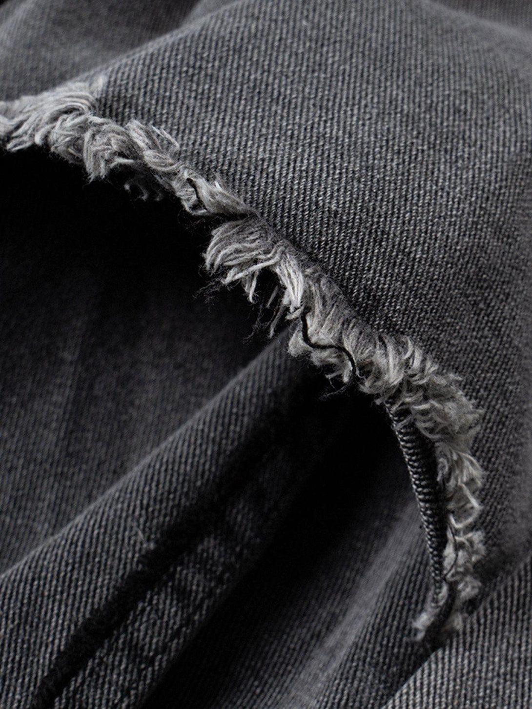 Intricate look at TALISHKO's deconstructed denim, focusing on fringe detail and fabric texture.